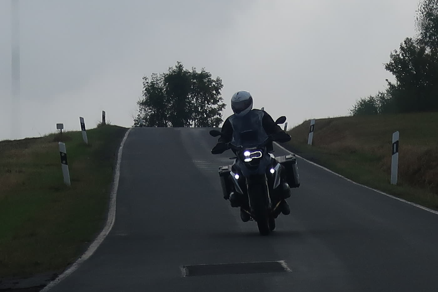 Motorrad fährt im Morgendunst eine Anhöhe im Saargau hinauf