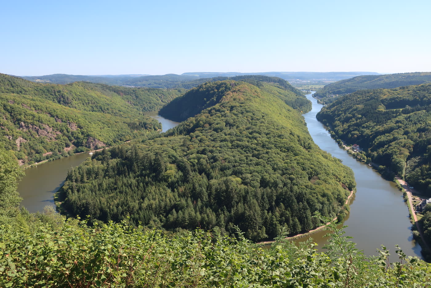 Die Saarschleife von oben — der Fluss windet sich um den bewaldeten Bergrücken Die Saarschleife von oben — der Fluss windet sich um den bewaldeten Bergrücken
